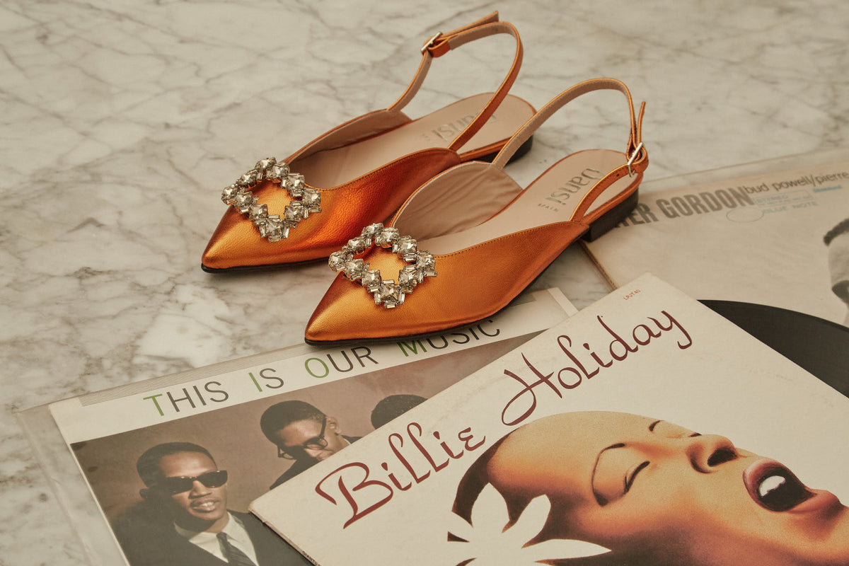 Zapatos naranjas de Dansi junto a una revista